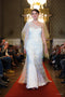 Robe de mariée Forever & Ever Ousman O. en dentelle de soie et crêpe de soie, avec manches longues transparentes, coupe asymétrique et grand voile en soie, présentée lors d’un défilé.