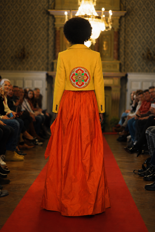 Défilé chateau thierry Dos ensemble veste jaune et jpe orange